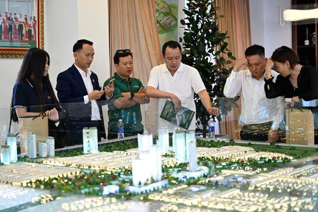 Khách hàng chăm chú theo dõi chuyên viên tư vấn qua sa bàn dự án